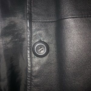 Medium KC collection black leather jacket as a small tear by the button.